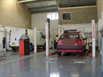 A tester at work in our hall, with a hatchback on the bay and a van alongside